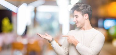 Yakışıklı delikanlı üzerinden hayran ve el ile sunulması ve parmak ile işaret ederken kameraya gülümseyen izole arka plan.