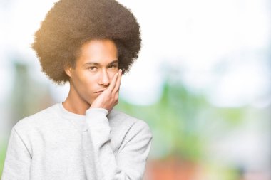 Sportif kazak düşünme seyir giyen afro saçlı genç Afro-Amerikan adam yorgun ve sıkılmış çapraz silah depresyon sorunları ile.