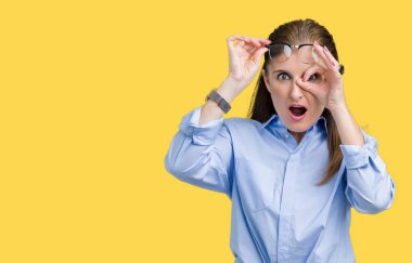 Sürpriz yüz, göz parmaklarının arasından seyir ile ok jest yapıyor izole arka plan üzerinde gözlük güzel orta yaş olgun iş kadını şok. İmansız ifade.