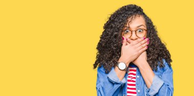 Genç güzel kadın kıvırcık saçlı gözlüklü ağız hata için elleriyle kapsayan şok. Gizli kavramı.