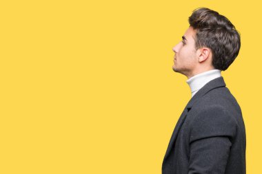 Zarif delikanlı giyen kış ceket izole arka tarafına, seyir üzerinde dinlenmek doğal yüz emin gülümseme ile pozuyla profili.