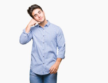 Genç yakışıklı iş adamı yapıyor gülümseyen izole arka plan üzerinde telefon hareketi ile el ve parmak telefonda konuşuyor gibi. Kavramları iletişim.