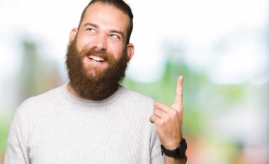 Genç Sarışın başarılı fikirle giyen sıradan kazak işaret parmağı adam. Çıktıktan ve mutlu. Bir numara.