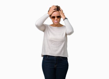 Güzel genç Afro-Amerikan kadın güneş gözlüğü takmış çünkü umutsuz ve stresli baş ağrısı acı izole arka plan üzerinde ağrı ve migren. Ellerini kafasına.