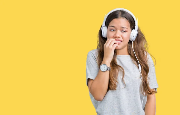 Молода Красива Жінка Навушниках Слухає Музику Ізольованому Фоні Виглядає Напруженою — стокове фото