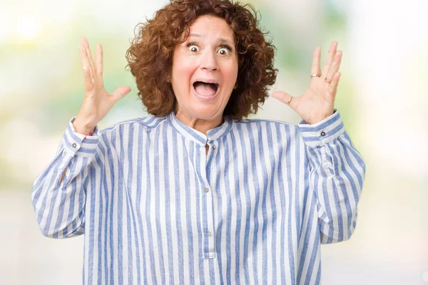 Üzerinde Donanma forması giyen güzel orta ager üst düzey kadın deli kutluyor arka plan izole ve başarı için kaldırdı kollarını açarak hayrete ve heyecanlı çığlık gözleri açık. Kazanan kavramı