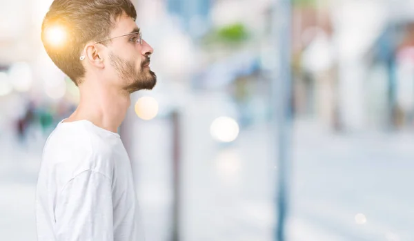 Όμορφος Νεαρός Φορώντας Γυαλιά Ηλίου Πέρα Από Απομονωμένο Υπόβαθρο Ψάχνει — Φωτογραφία Αρχείου