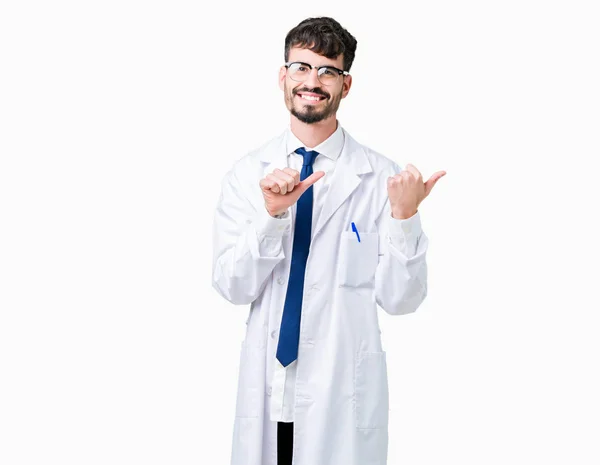 年轻的专业科学家男子穿着白色外套在孤立的背景指向后面的背后 手和竖起大拇指 面带微笑自信 — 图库照片