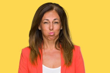 Güzel orta yaş iş komik surat ile yanakları şişirme izole arka plan yetişkin kadın. Ağız ile hava, deli ifade şişirilmiş.