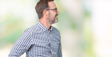 Yakışıklı orta yaş zarif üst düzey iş adam gözlük izole arka tarafına, seyir üzerinde dinlenmek doğal yüz emin gülümseme ile pozuyla profili.