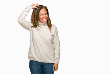 Güzel orta yaş yetişkin kadın giyiyor kış kazak izole arka plan üzerinde yanıltır ve soru hakkında merak ediyorum. Şüphe, kafasına el ile düşünme ile belirsiz. Dalgın kavramı.