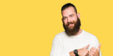 Kış kazak giyen genç hipster adam el ve başparmak ile arka arkasında Işaret, güven gülümseyen