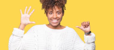 Güzel genç Afro-Amerikan kadın giyiyor kış kazak gösterilen ve parmakları ile işaret izole arka plan üzerinde kendinden emin ve mutlu gülümseyerek süre 6 numara.