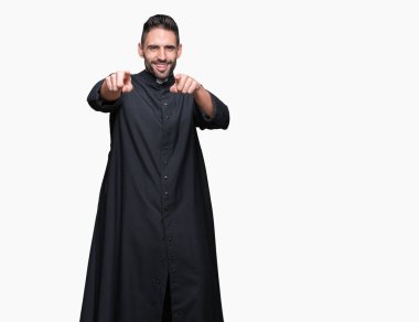 İzole arka plan üzerinde genç Hıristiyan rahip size Işaret ve parmak ile kamera, olumlu ve neşeli gülümseyen