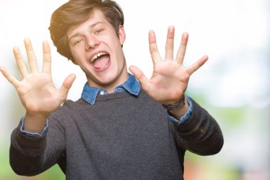 Genç yakışıklı zarif adam gösterilen ve parmakları ile işaret izole arka plan üzerinde kendinden emin ve mutlu gülümseyerek süre on numara.