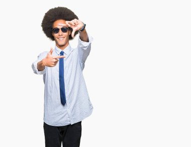 Elle yapma çerçeve ve parmakları ile mutlu yüz gülümseyen güneş gözlüğü takıyor afro saçlı genç Afro-Amerikalı iş adamı. Yaratıcılık ve Fotoğrafçılık kavramı.