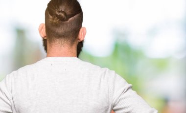 Genç Sarışın geriye doğru uzakta silah ile vücut üzerinde seyir giyen sıradan kazak duran adam