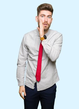 Genç yakışıklı iş adam elini ağzına kötü amaçlı konuşma konuşma fısıldayan gizli söylenti söylüyor