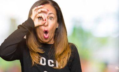 Güzel orta yaş kadın taş ve rulo kazak giymiş ok jest sürpriz yüz, göz parmaklar ile bakarak şok yapıyor. İnanılmaz ifade.