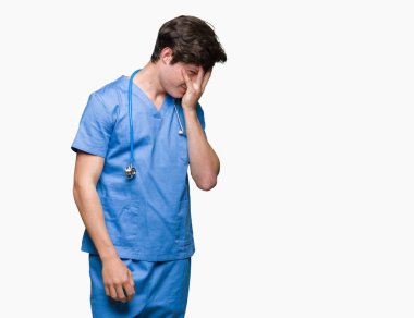 Üzgün ifade yüz eller ile ağlayarak süre kapsayan ile izole arka plan üzerinde tıbbi üniforma giyen genç doktor. Depresyon kavramı.