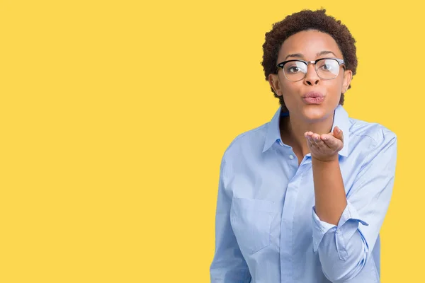 Young beautiful african american business woman over isolated background looking at the camera blowing a kiss with hand on air being lovely and sexy. Love expression.