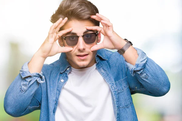 Joven Hombre Guapo Con Gafas Sol Sobre Fondo Aislado Tratando —  Fotos de Stock