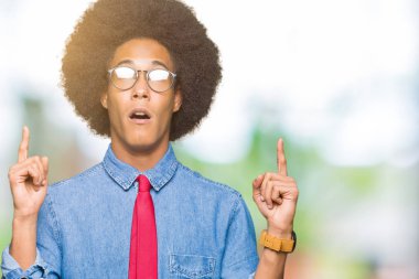 Gözlük ve kırmızı kravat giyen afro saçlı genç Afro-Amerikalı iş adamı şaşırtmak ve yukarıya bakıp parmakları ile işaret şaşırttı ve silah kaldırdı.