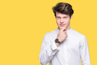 Genç yakışıklı iş adamı emin çapraz kollar ve çeneme kaldırdı el ile gülümseme ile kameraya bakarak izole arka plan üzerinde. Pozitif düşünce.