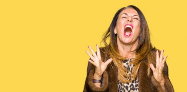 Güzel orta yaş zarif kadın vizon ceket deli ve deli çığlık giyiyor ve agresif ifade ve silah ile bağırdı kaldırdı. Hayal kırıklığı kavramı.