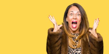 Güzel orta yaş zarif kadın vizon ceket deli kutluyor giyen ve heyecanlı çığlık açık gözleri ve yükseltilmiş silah ile başarı için hayran. Kazanan kavramı