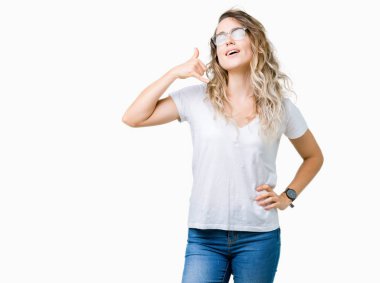 İşin gülümseyen izole arka plan üzerinde gözlük güzel sarışın genç kadın telefon hareketi ile el ve parmak telefonda konuşuyor gibi. Kavramları iletişim.