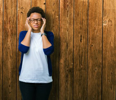 Genç güzel Afrikalı-Amerikalı kadın üzerinde gözlük takan izole arka plan baş baş ağrısı için el ile çünkü stres. Migren muzdarip.