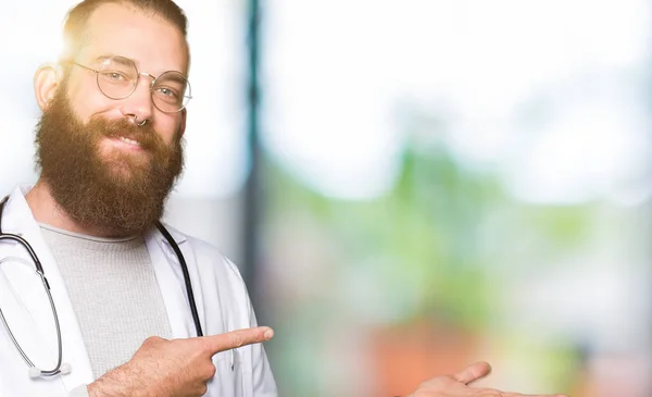 Joven Médico Rubio Con Barba Vistiendo Abrigo Médico Asombrado Sonriendo —  Fotos de Stock