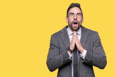 Genç yakışıklı iş adamı yalvarıyor ve umut ifade yüzünde çok duygusal ve endişe ile birlikte elleriyle dua izole arka plan üzerinde. Bağışlanmak. Din kavramı.