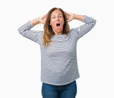 Giyen güzel orta yaş kadın kazak izole arka plan deli üzerinde çizgili ve baş, korkuyor ve açık ağzı ile şok sürpriz elleriyle korkuttu