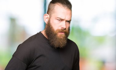 Çünkü mide üzerinde el ile rahat t-shirt giyen genç sarışın adam hazımsızlık, ağrılı hastalık hasta hissediyor. Ağrısı kavramı.