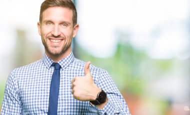 Yakışıklı iş adamı mutlu yaşasın el ile jest yapıyor kravat takıyor. Başarı gösteren kameraya bakarak ifade onaylama.