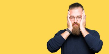 Gözlük ve balıkçı yaka kazak giyen genç sarışın adam yorgun eller yüz, depresyon ve üzüntü kapsayan, üzgün ve sorun için tahriş