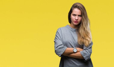 Genç güzel sarışın kadın izole arka plan şüpheci ve çapraz kolları olan yüzündeki gergin, onaylamayan ifade yüzünden. Negatif kişi.