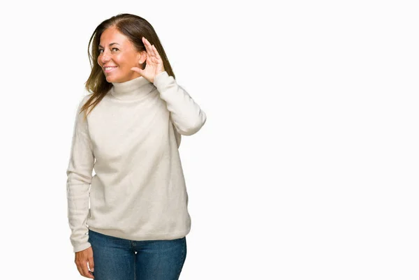 美しい中年成人女性は 噂やゴシップに審理をリスニングの耳に手を浮かべて隔離された背景に冬のセーターを着ています 難聴の概念 — ストック写真