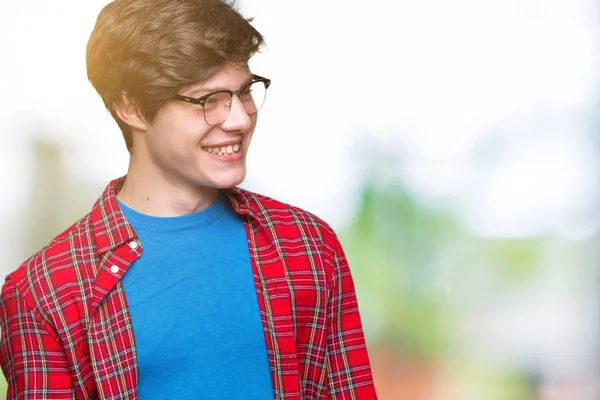 年轻英俊的学生戴着眼镜在孤立的背景看着一边面带微笑 自然的表情 笑自信 — 图库照片