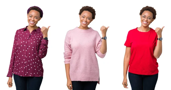 非洲裔美国妇女与非洲头发在孤立的背景微笑与愉快的面孔看 用拇指指向旁边 — 图库照片