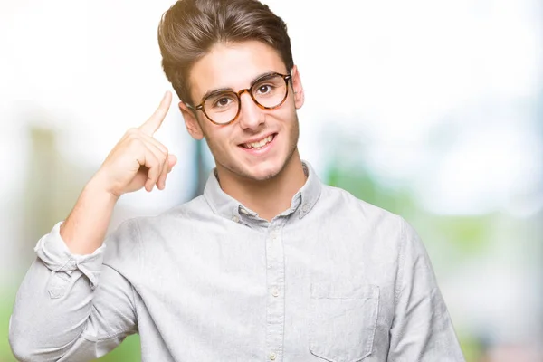 Homem Bonito Jovem Usando Óculos Sobre Fundo Isolado Sorrindo Apontando — Fotografia de Stock