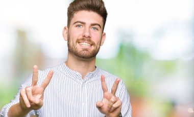 Zafer işareti yapıyor parmak gösterilen kamera seyir gülümseyen yakışıklı delikanlı. İki numaralı.