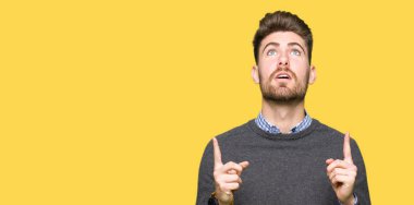 Genç yakışıklı zarif adam hayret ve yukarıya bakıp parmakları ile işaret şaşırttı ve silah kaldırdı.