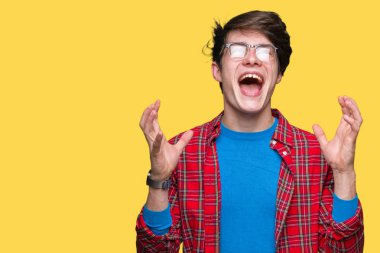 Genç yakışıklı öğrenci adam izole arka plan üzerinde gözlük takan kollarını kaldırdı ve kapalı gözleri heyecanlı çığlık ile başarı için deli ve deli kutluyor. Kazanan kavramı