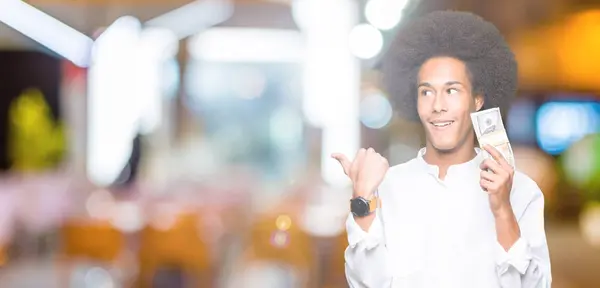 Joven Hombre Afroamericano Con Pelo Afro Sosteniendo Manojo Dólares Señalando —  Fotos de Stock