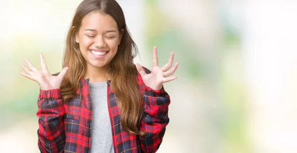 年轻美丽的黑发女人穿着一件夹克在孤立的背景庆祝疯狂和疯狂的成功与手臂抬起和闭上的眼睛尖叫兴奋 优胜者概念 — 图库照片