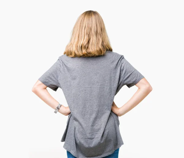 美丽的年轻女子穿着超大尺寸的休闲 T恤在孤立的背景站向后看着远离身体上的手臂 — 图库照片