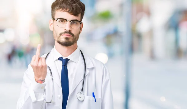 Junger Arzt Trägt Krankenhausmantel Über Isoliertem Hintergrund Und Zeigt Mittelfinger — Stockfoto